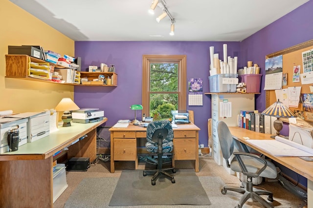 carpeted home office featuring track lighting