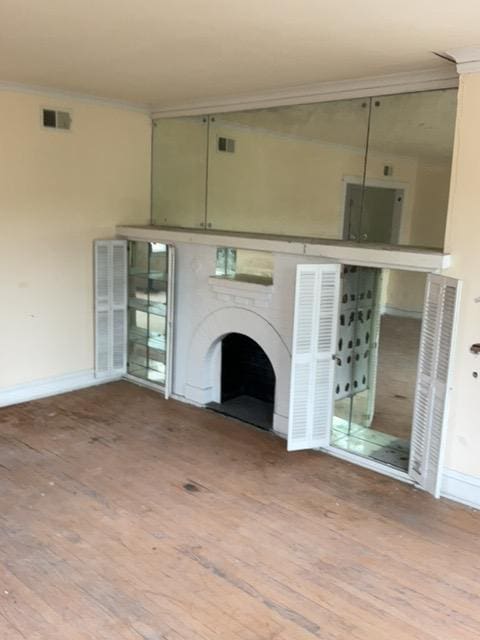 unfurnished living room with light hardwood / wood-style flooring and ornamental molding