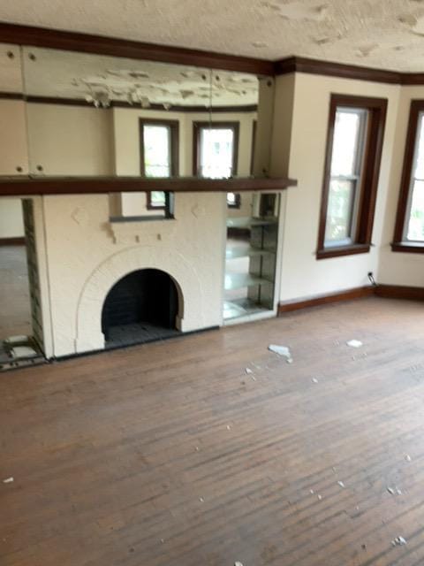 unfurnished living room with crown molding and hardwood / wood-style flooring