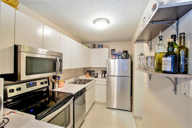 kitchen featuring white cabinets, appliances with stainless steel finishes, sink, and a textured ceiling