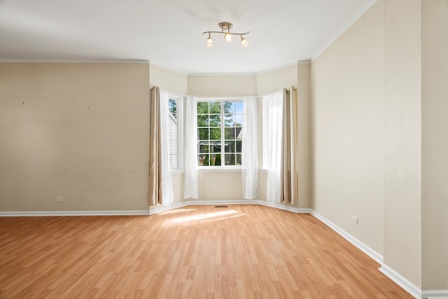 unfurnished room featuring ornamental molding and light wood-type flooring