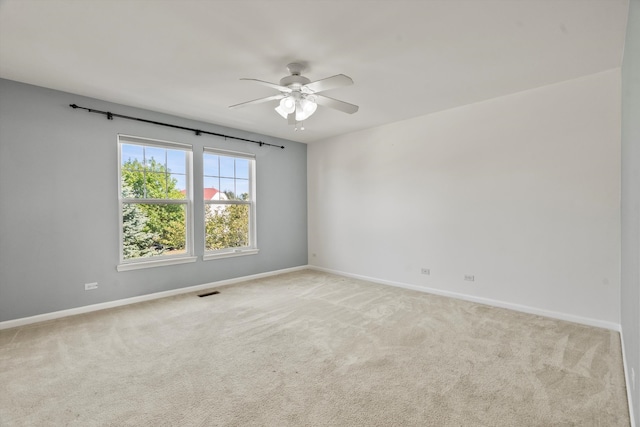 carpeted spare room featuring ceiling fan