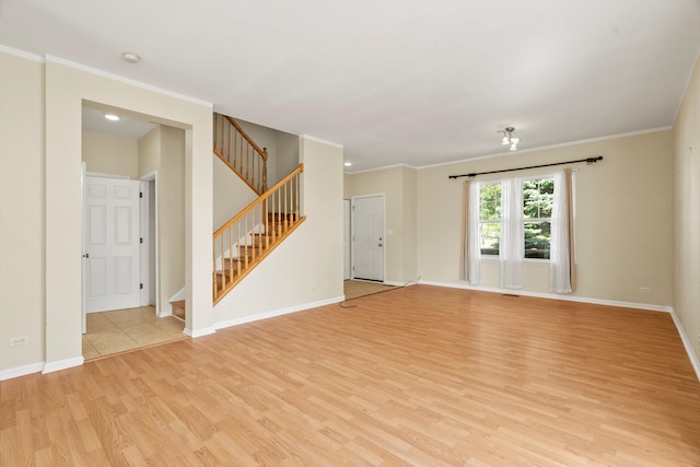 spare room with crown molding and light wood-type flooring