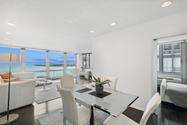 dining space with wood-type flooring and a water view