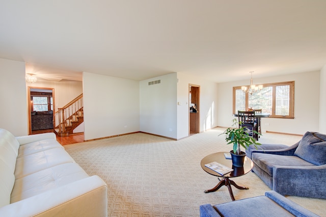 carpeted living room featuring an inviting chandelier