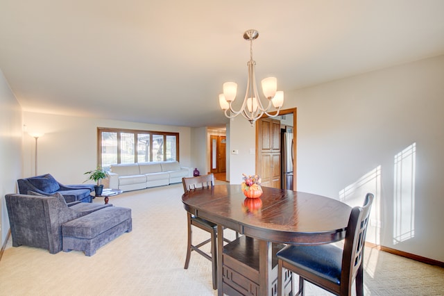 dining area featuring an inviting chandelier and light carpet