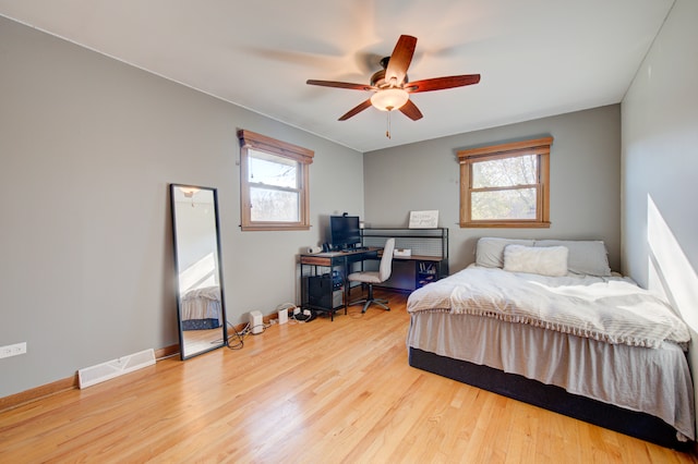 bedroom with multiple windows, light wood-type flooring, and ceiling fan