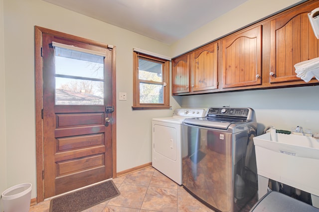 laundry area featuring washer and clothes dryer, cabinets, sink, and light tile patterned flooring