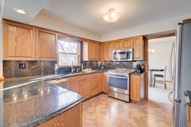 kitchen featuring decorative backsplash, appliances with stainless steel finishes, light tile patterned floors, and sink