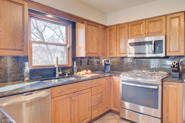 kitchen with light tile patterned floors, stainless steel appliances, sink, and decorative backsplash