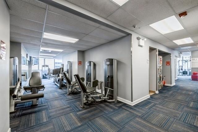 exercise room featuring a paneled ceiling and dark carpet