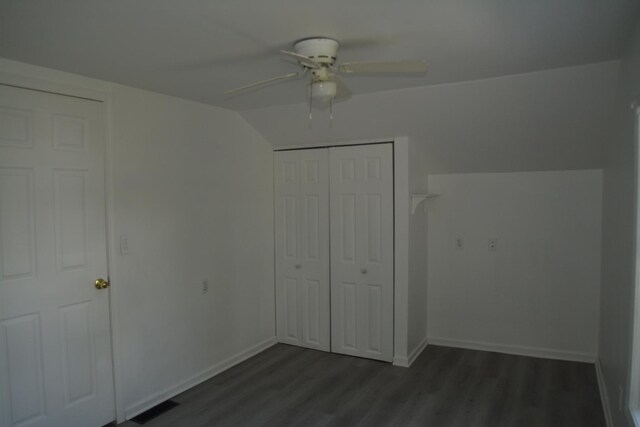 unfurnished bedroom with ceiling fan, dark hardwood / wood-style floors, a closet, and vaulted ceiling