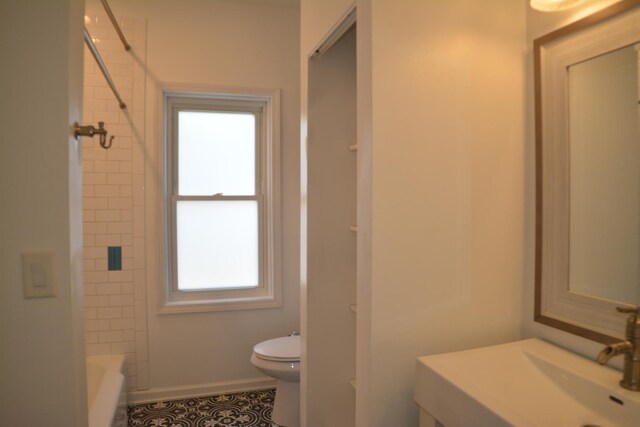 full bathroom with tiled shower / bath, toilet, and sink