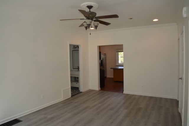 unfurnished bedroom with ornamental molding, connected bathroom, ceiling fan, and dark hardwood / wood-style floors