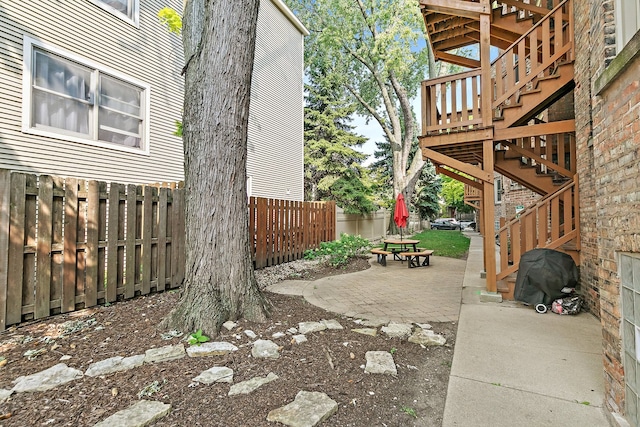 view of yard with a wooden deck and a patio