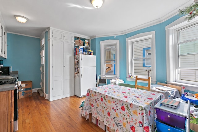 bedroom featuring ornamental molding, light hardwood / wood-style flooring, and white fridge