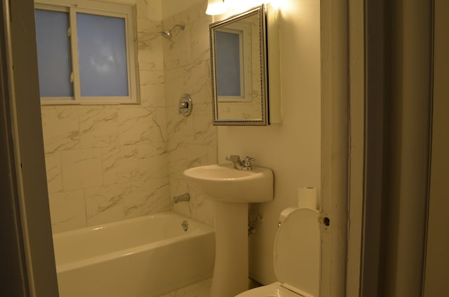 bathroom with tiled shower / bath and toilet