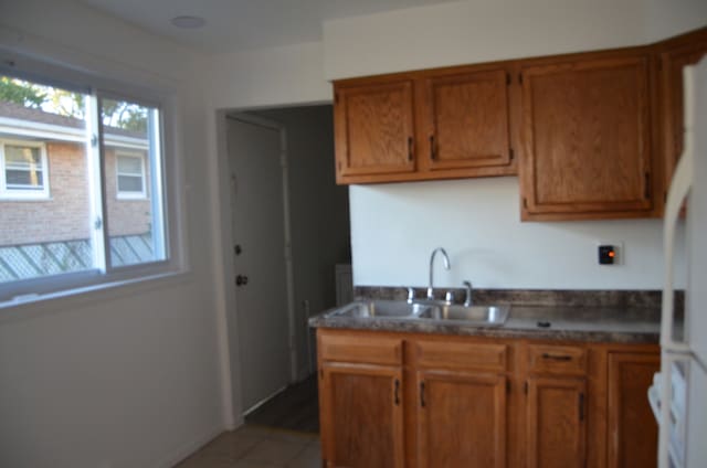 kitchen featuring tile patterned floors, sink, and white refrigerator