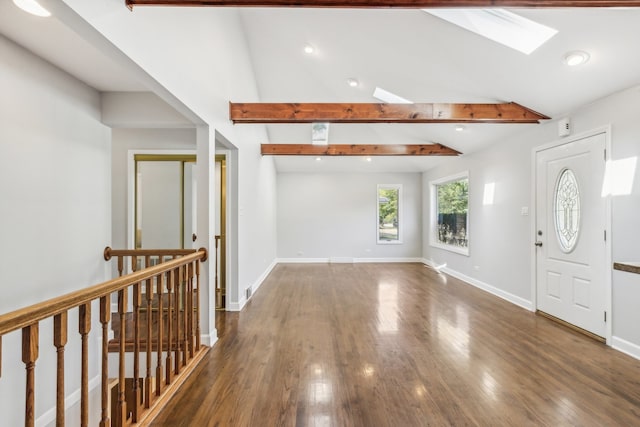 entrance foyer with vaulted ceiling with skylight and dark hardwood / wood-style flooring