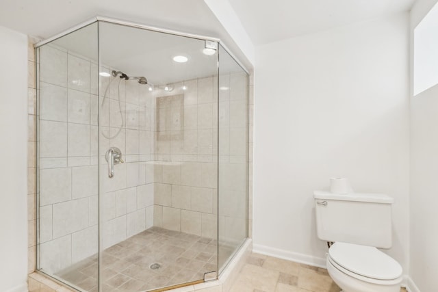 bathroom featuring a shower with door, tile patterned floors, and toilet