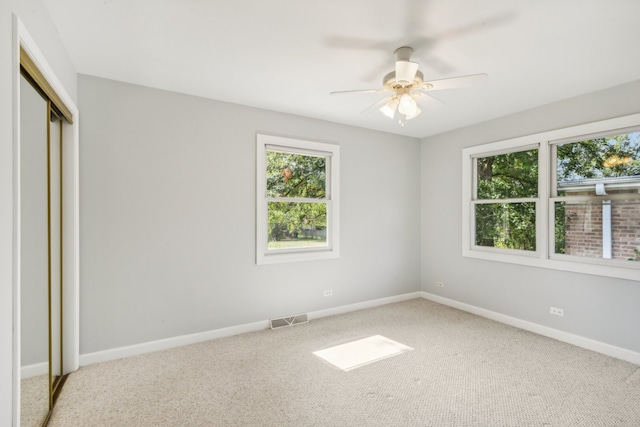 unfurnished bedroom featuring light carpet, a closet, and ceiling fan