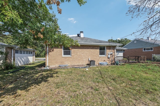 back of property with central AC, a yard, and a wooden deck