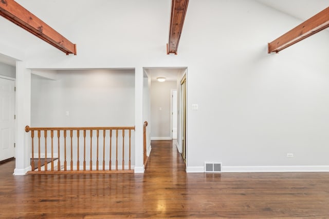 empty room with dark wood-type flooring and beamed ceiling