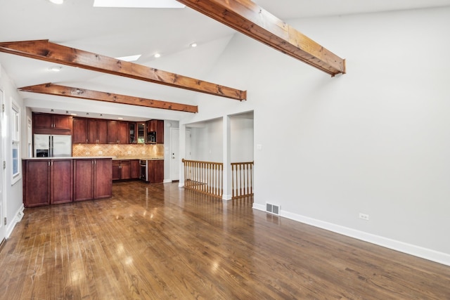 unfurnished living room featuring beamed ceiling, high vaulted ceiling, a skylight, and dark hardwood / wood-style flooring