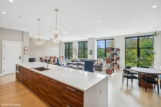 kitchen with a sink, modern cabinets, healthy amount of natural light, light wood-style floors, and recessed lighting