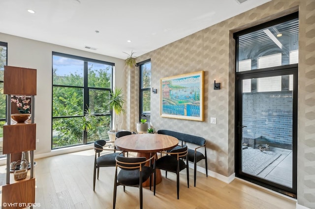 dining room with wallpapered walls, light wood finished floors, baseboards, plenty of natural light, and recessed lighting
