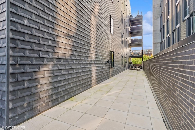 view of property exterior featuring brick siding and a patio area