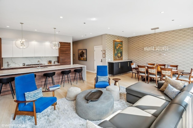 living area featuring wallpapered walls, light wood-style floors, recessed lighting, and baseboards
