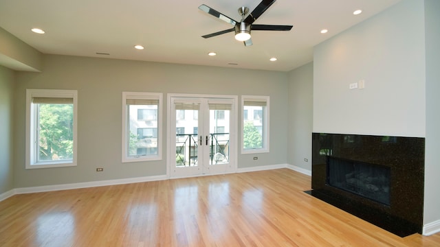 unfurnished living room with french doors, ceiling fan, light hardwood / wood-style flooring, and a healthy amount of sunlight