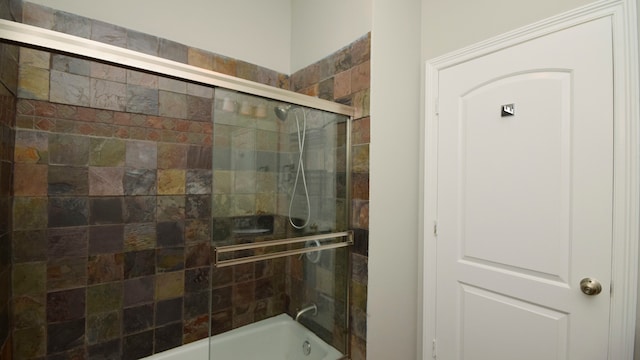 bathroom featuring combined bath / shower with glass door