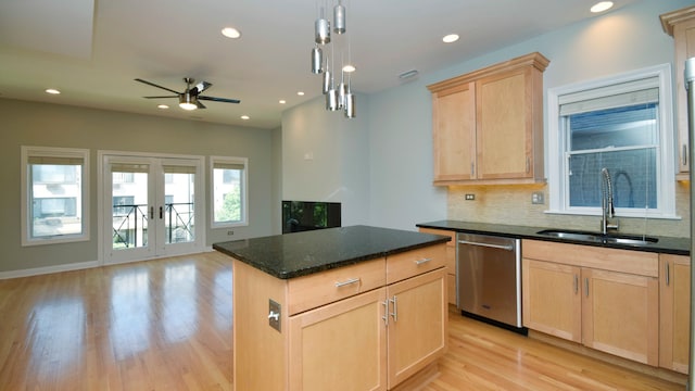 kitchen featuring a kitchen island, light brown cabinetry, ceiling fan, stainless steel dishwasher, and sink