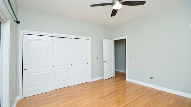 unfurnished bedroom featuring ceiling fan, light wood-type flooring, and a closet