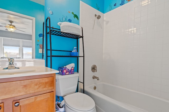 full bathroom with ceiling fan, toilet, tiled shower / bath, and vanity