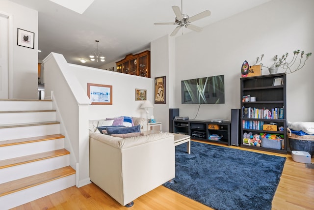 living room featuring hardwood / wood-style floors and ceiling fan with notable chandelier