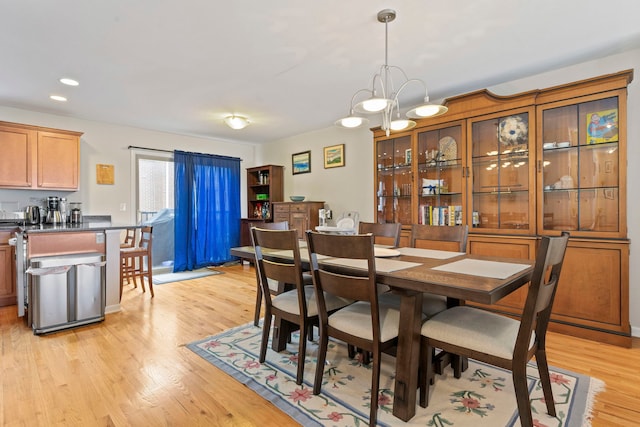 dining area with a notable chandelier and light hardwood / wood-style flooring