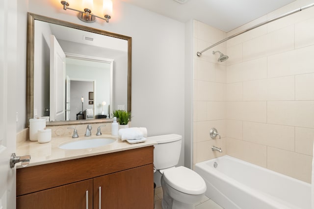 full bathroom featuring tiled shower / bath, vanity, toilet, and tile patterned flooring