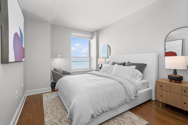 bedroom featuring a water view and light hardwood / wood-style floors