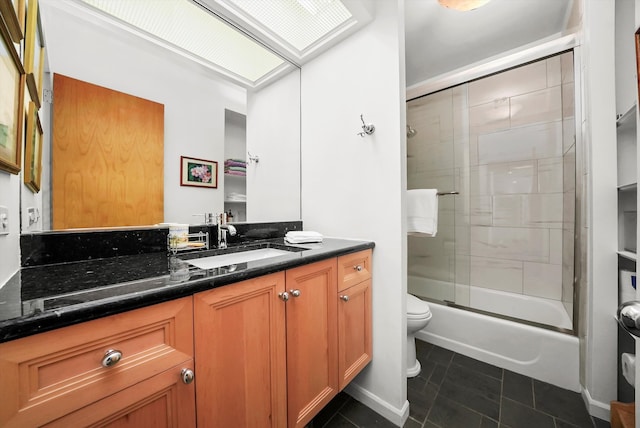 full bathroom with tile patterned floors, bath / shower combo with glass door, vanity, and toilet