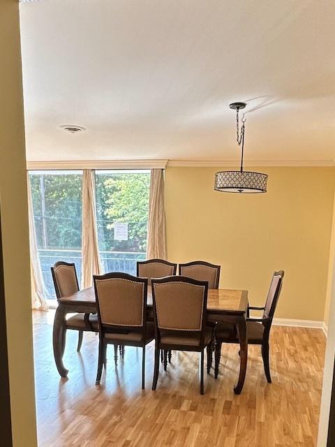 dining room with light wood-type flooring and ornamental molding