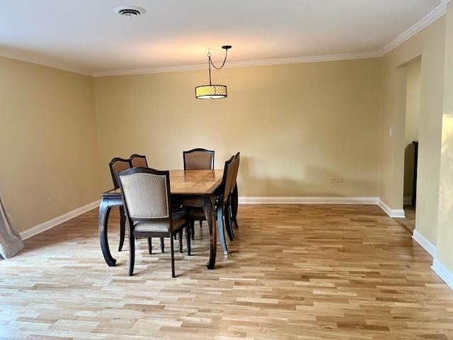 dining room featuring crown molding and light hardwood / wood-style floors