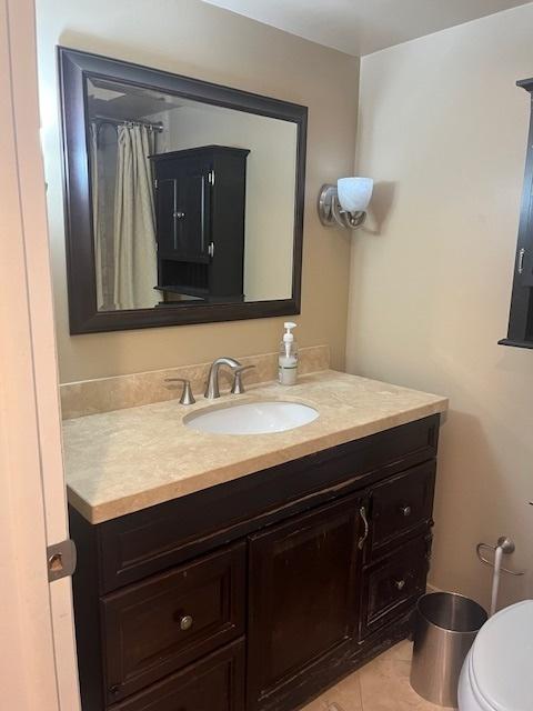 bathroom with tile patterned flooring, toilet, and vanity