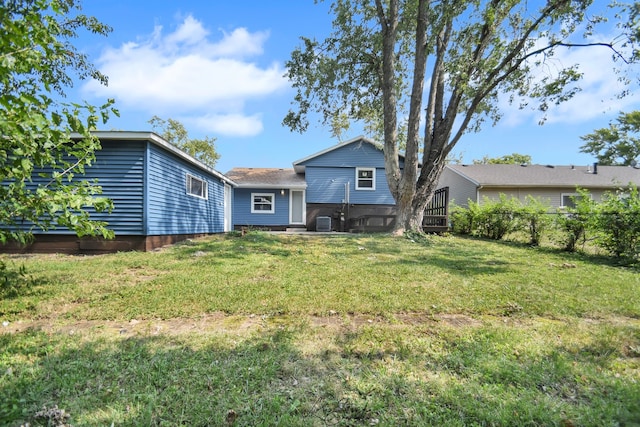 rear view of property featuring a lawn and central air condition unit