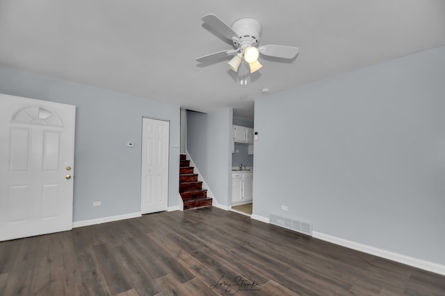 spare room with dark wood-type flooring, sink, and ceiling fan