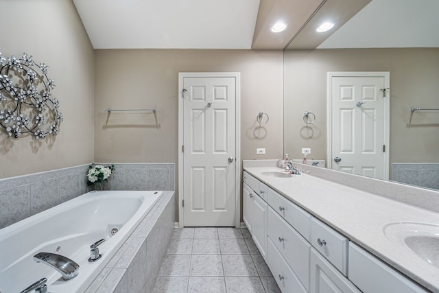 bathroom featuring tile patterned floors, tiled bath, and vanity