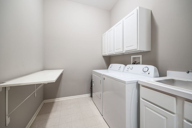 clothes washing area with cabinets, sink, and independent washer and dryer