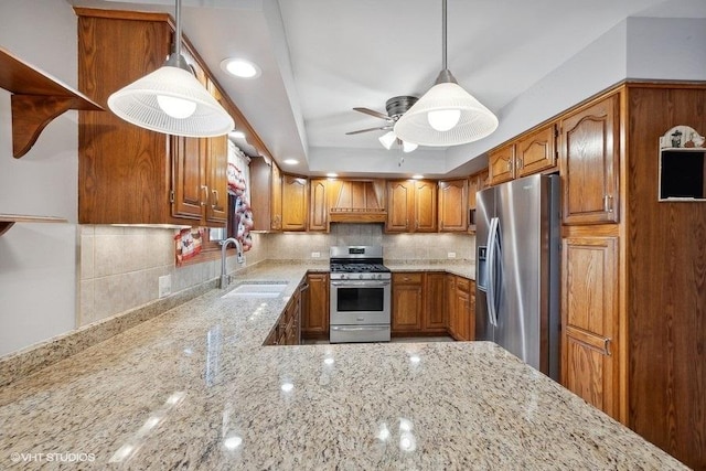 kitchen featuring decorative backsplash, appliances with stainless steel finishes, premium range hood, a raised ceiling, and sink